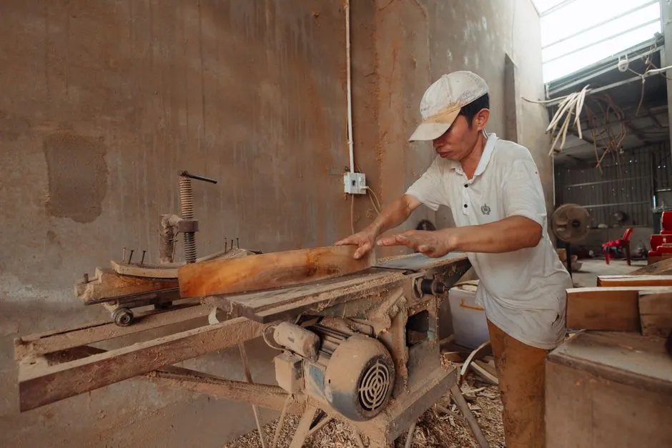 Geste d un menuisier sur sa raboteuse en atelier