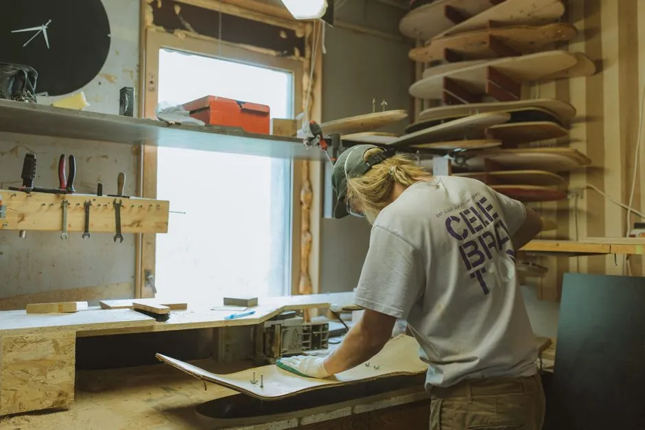 Artisan travaillant une planche dans son atelier de menuiserie
